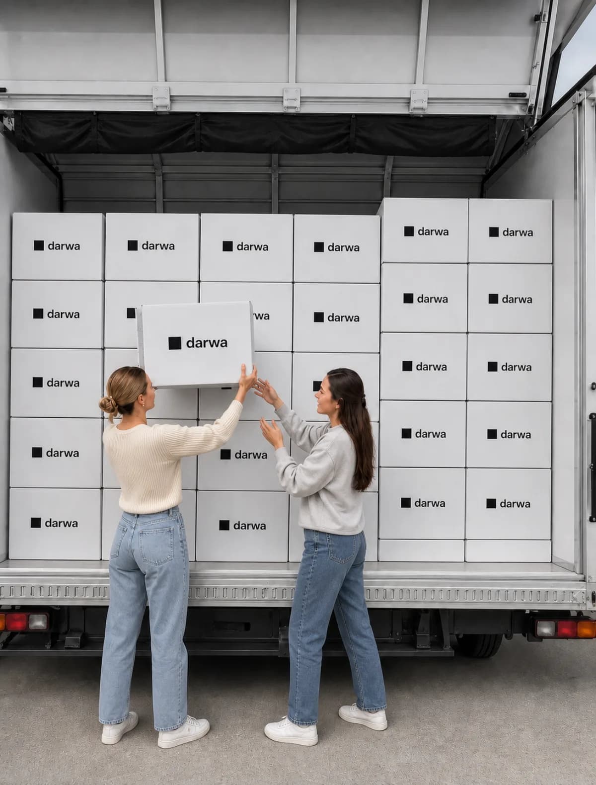 Two people loading Darwa-branded shipping boxes into a delivery truck